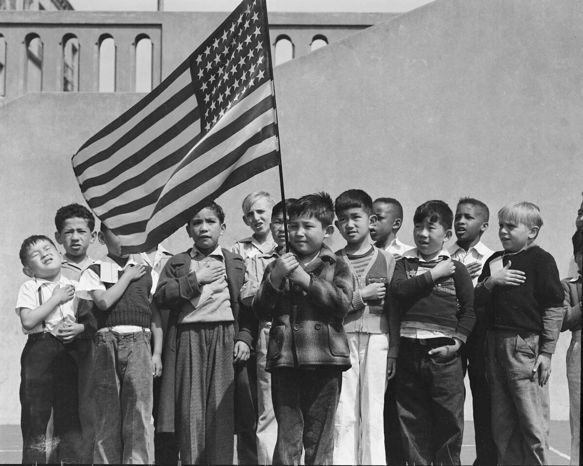 Лишь в 1976-м президент Форд признал, что интернирование было «неправильным» . В 1988 президент Рейган подписал указ о выплате интернированным японцам компенсации.На фото: японские дети приносят клятву верности американскому флагу.