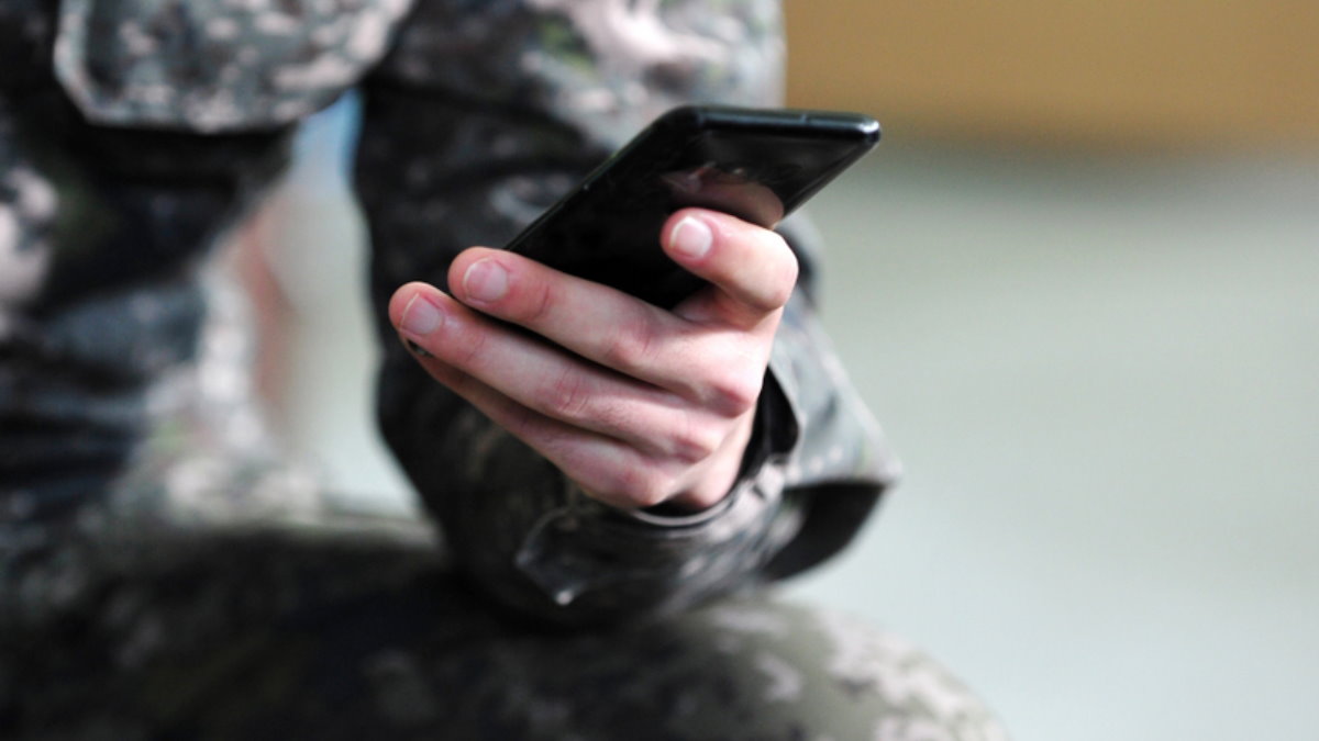 Солдат военный с телефоном смартфоном