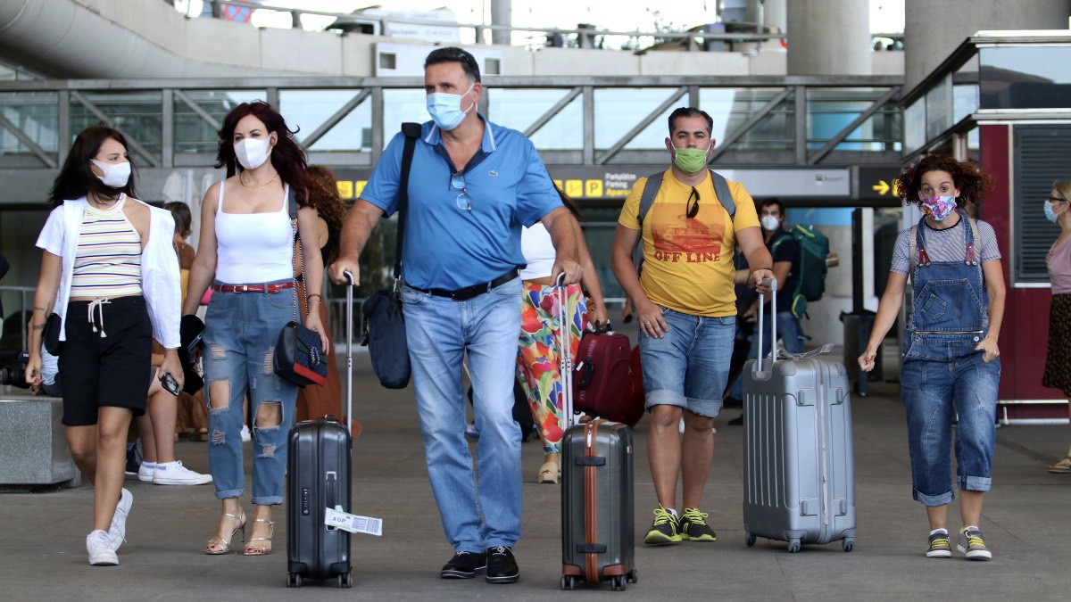 туристы с чемоданами в аэропорту