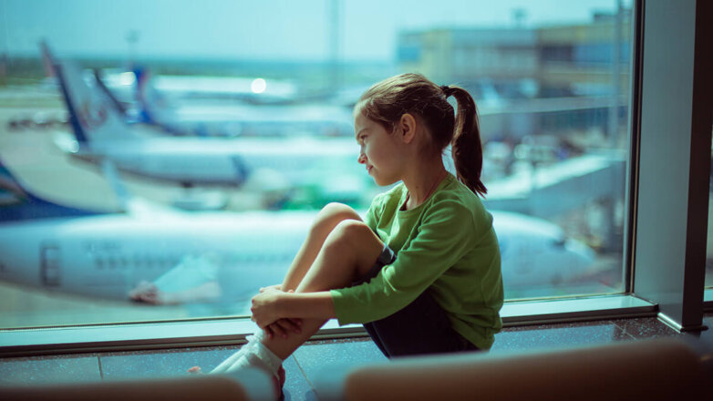 Ребенок у окна в аэропорту.