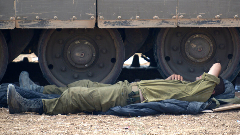 солдат спит возле танка