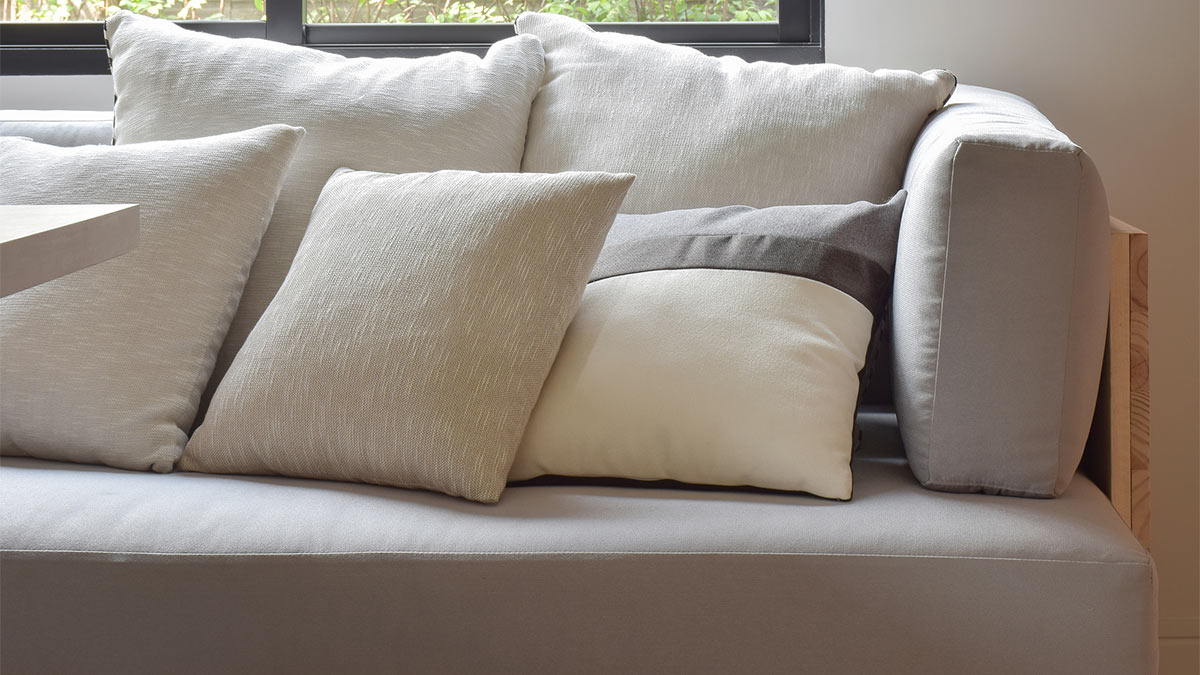 Серый диван с бежевыми подушками