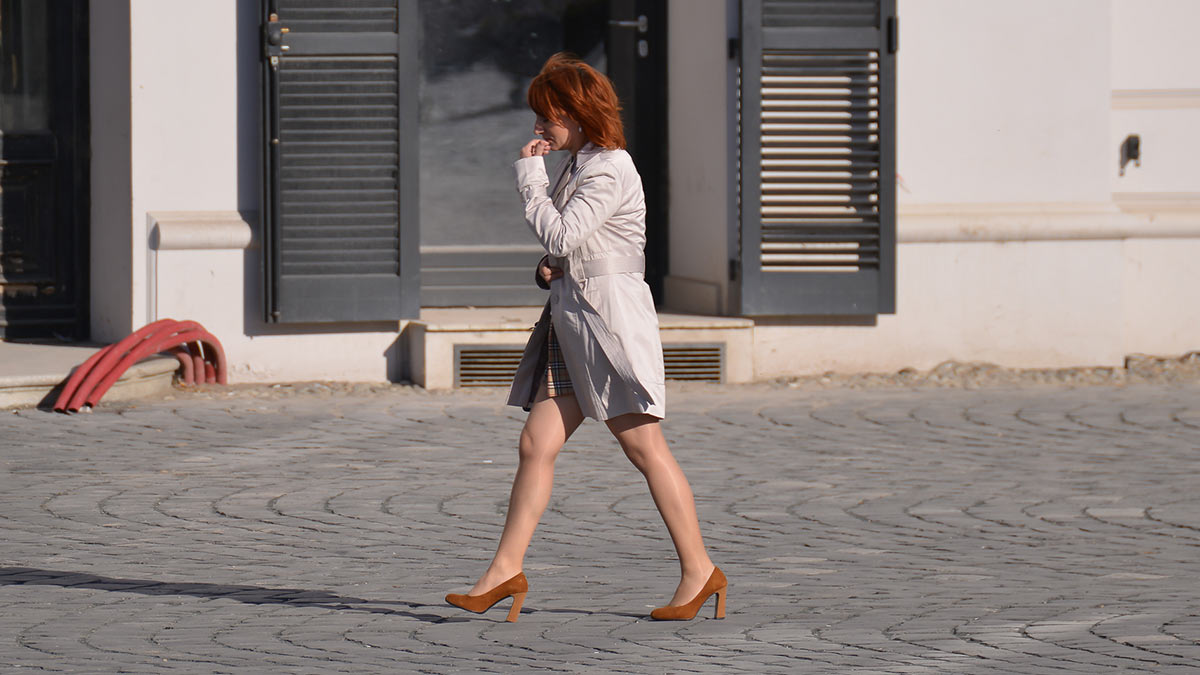 Женщина в колготках телесного цвета идет по улице