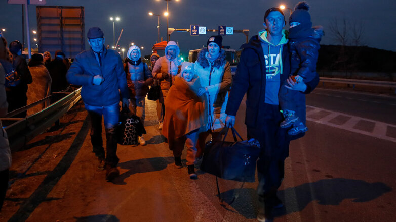 Беженцы с детьми и личными вещами прибывают в Польшу