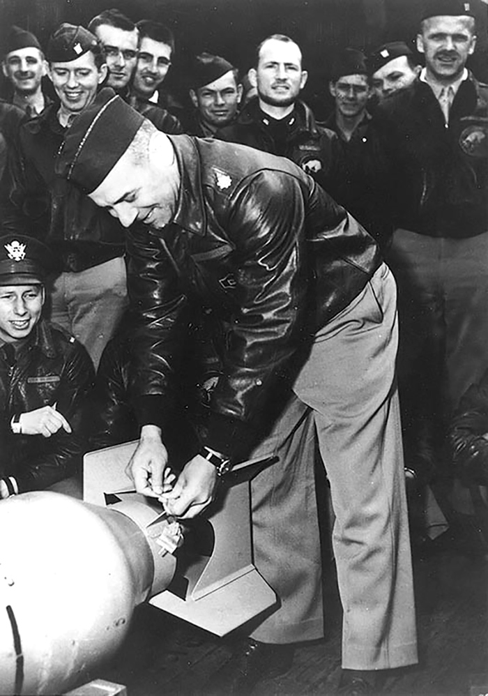 Подполковник ВВС США Джеймс Х. Дулиттл прикрепляет японскую медаль к бомбе за "возвращение" ее создателям