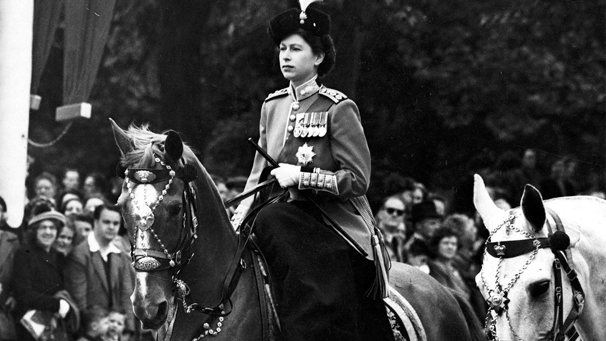 Принцесса Елизавета (ныне королева Елизавета II) едет верхом на лошади во время церемонии вручения знамени. Июнь 1951 года