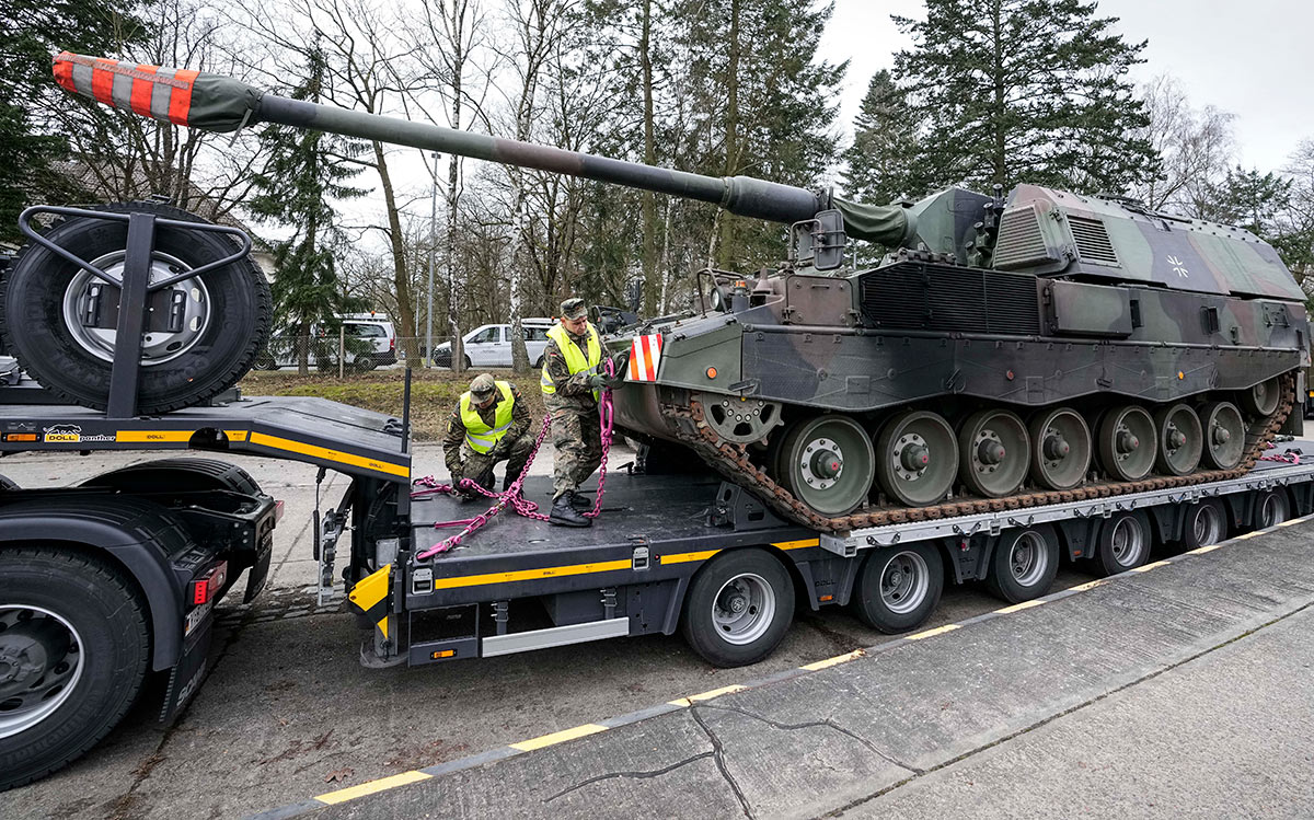 Немецкие солдаты загружают самоходные артиллерийские установки для перевозки в Литву