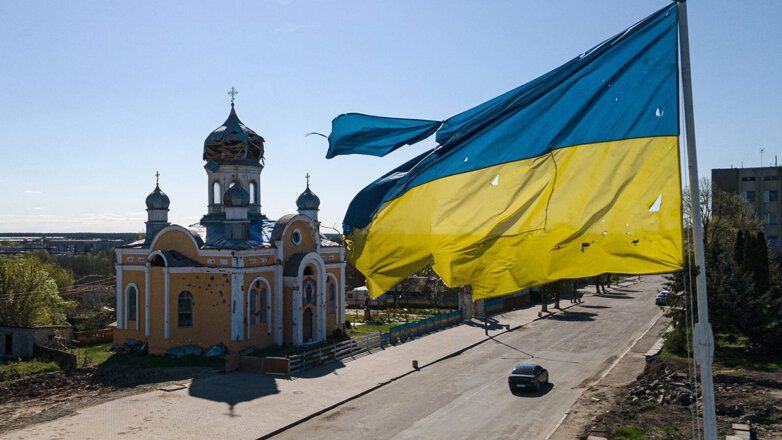 Разорванный флаг Украины на фоне церкви