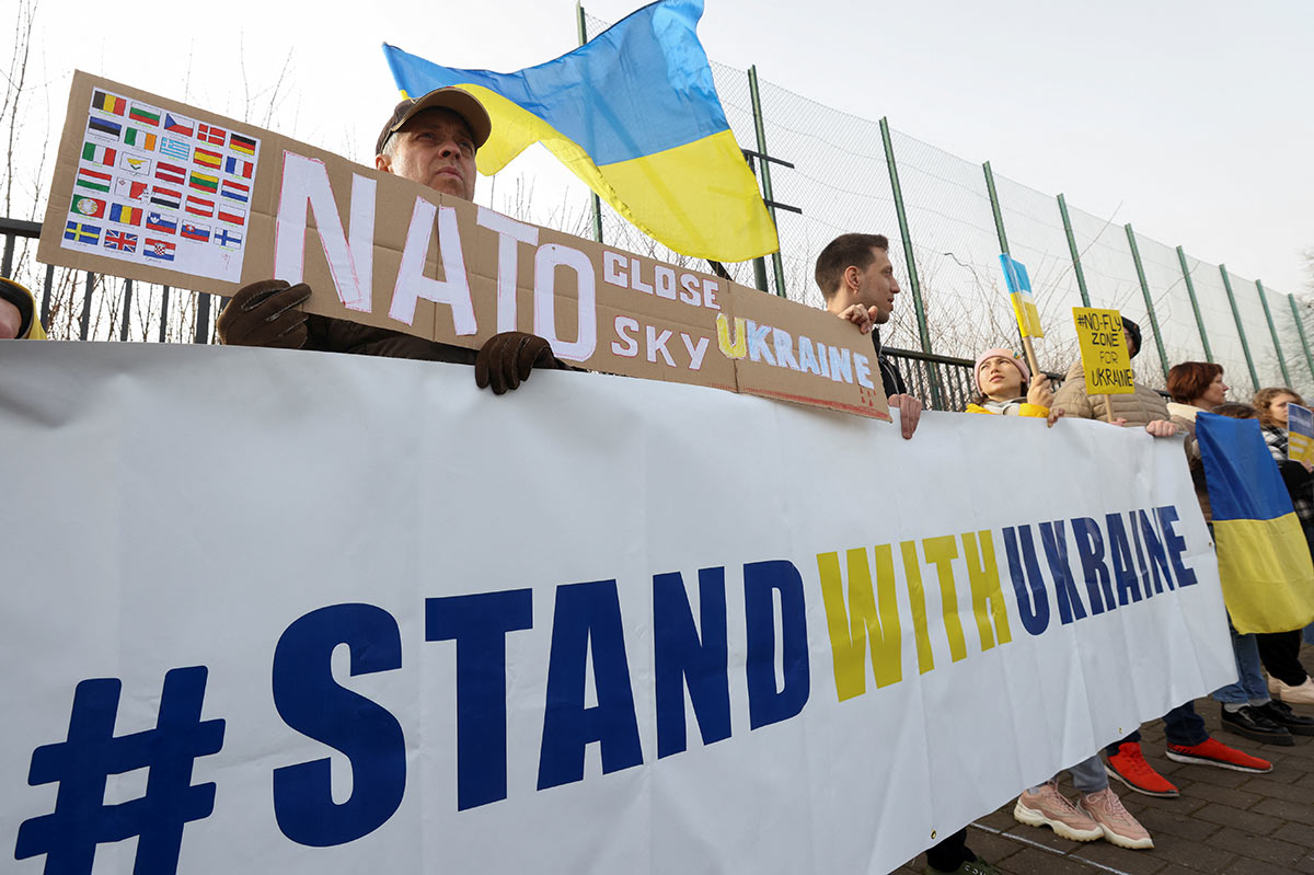 Люди держат плакаты во время демонстрации в поддержку Украины