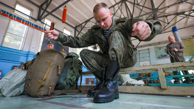Мобилизованный мужчина получает военную форму в пункте приема личного состава