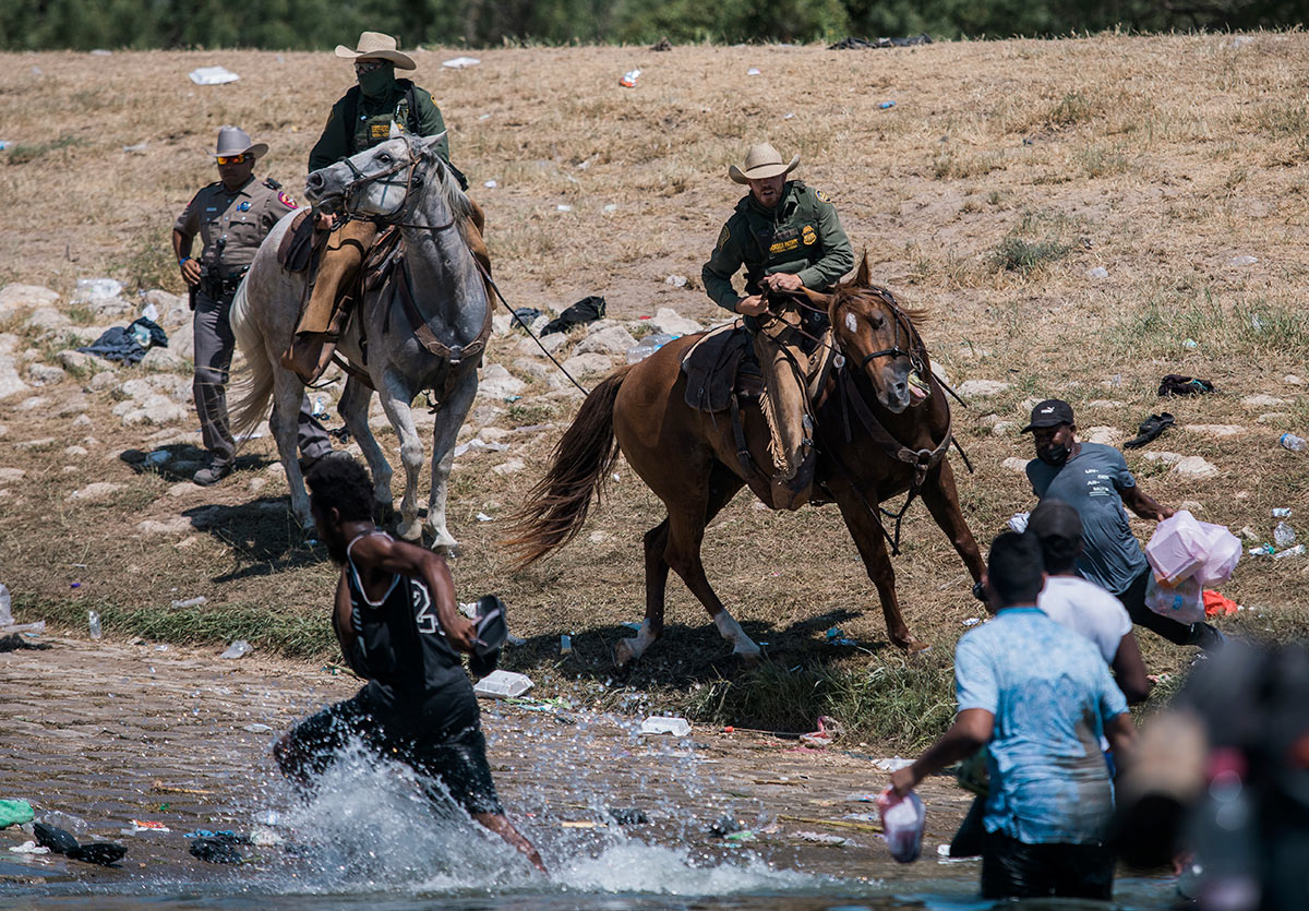 Сотрудники пограничного патруля США сдерживают мигрантов при пересечении границы