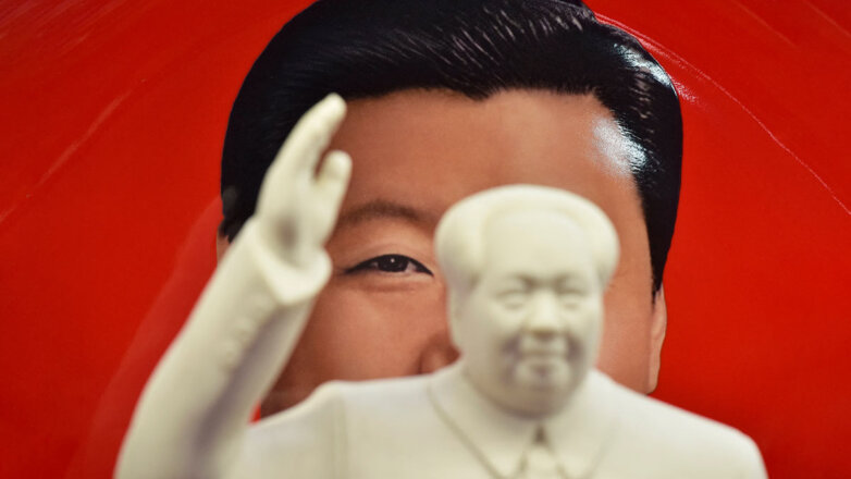 Статуэтка Мао Цзэдуна на фоне портрета Си Цзиньпина
