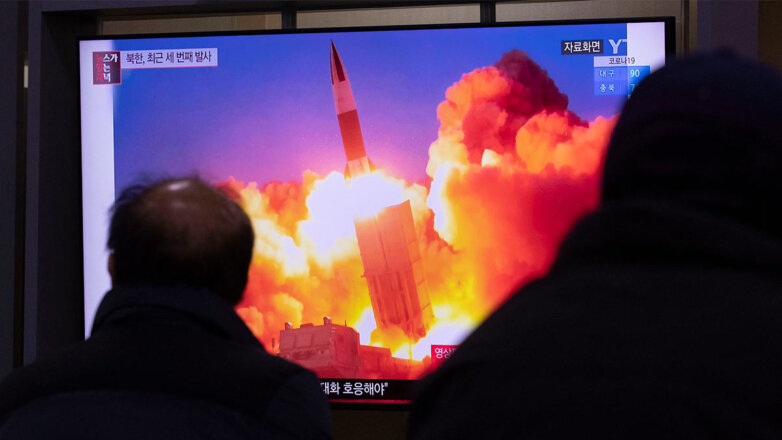 Люди наблюдают по телевизору за запуском баллистической ракеты КНДР