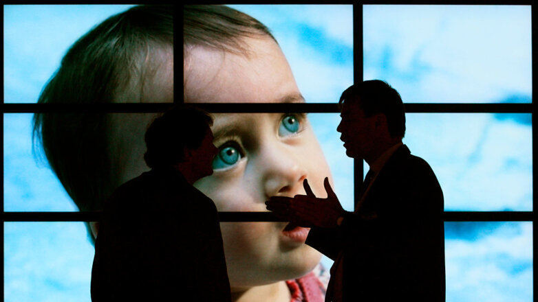 Мужчины у монитора с изображением ребенка