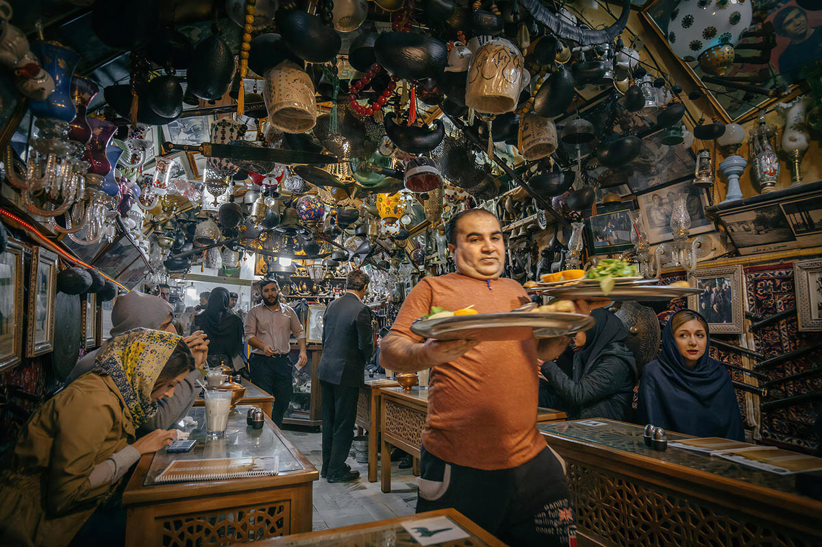Туристы и местные жители в кафе в Исфахане в Иране