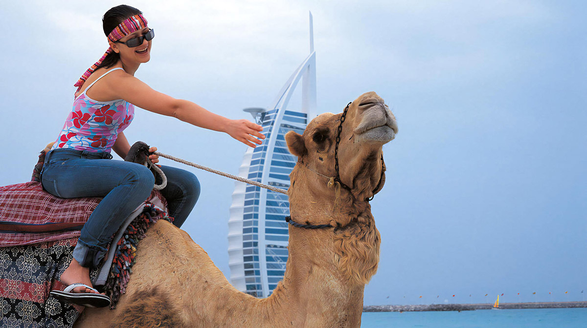 Туристка на верблюде в Дубае