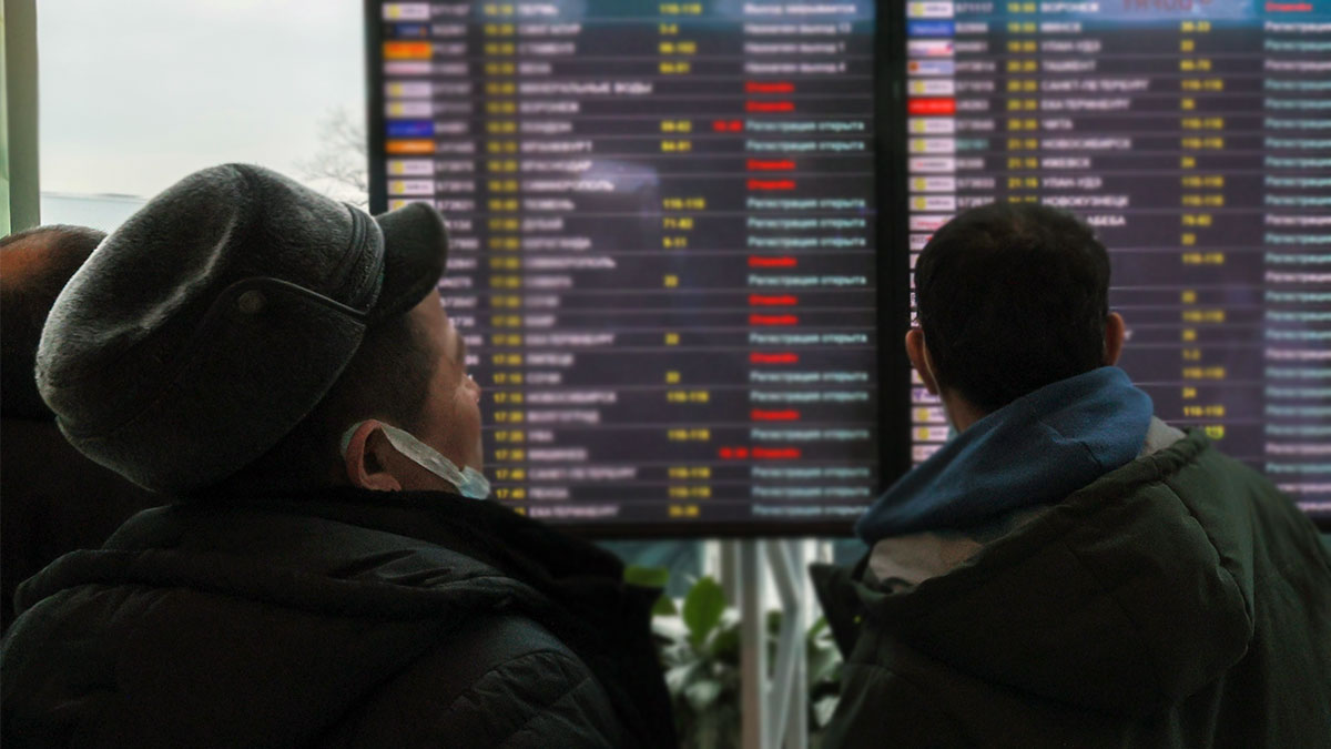 Пассажиры у табло вылета в аэропорту Домодедово