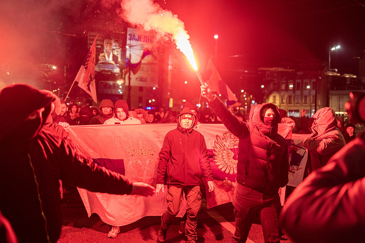 Демонстранты зажигают факелы во время митинга в поддержку этнических сербов в Белграде