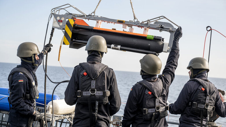 Военнослужащие используют кран для перемещения подводного беспилотника SeaFox в море перед испытательным запуском