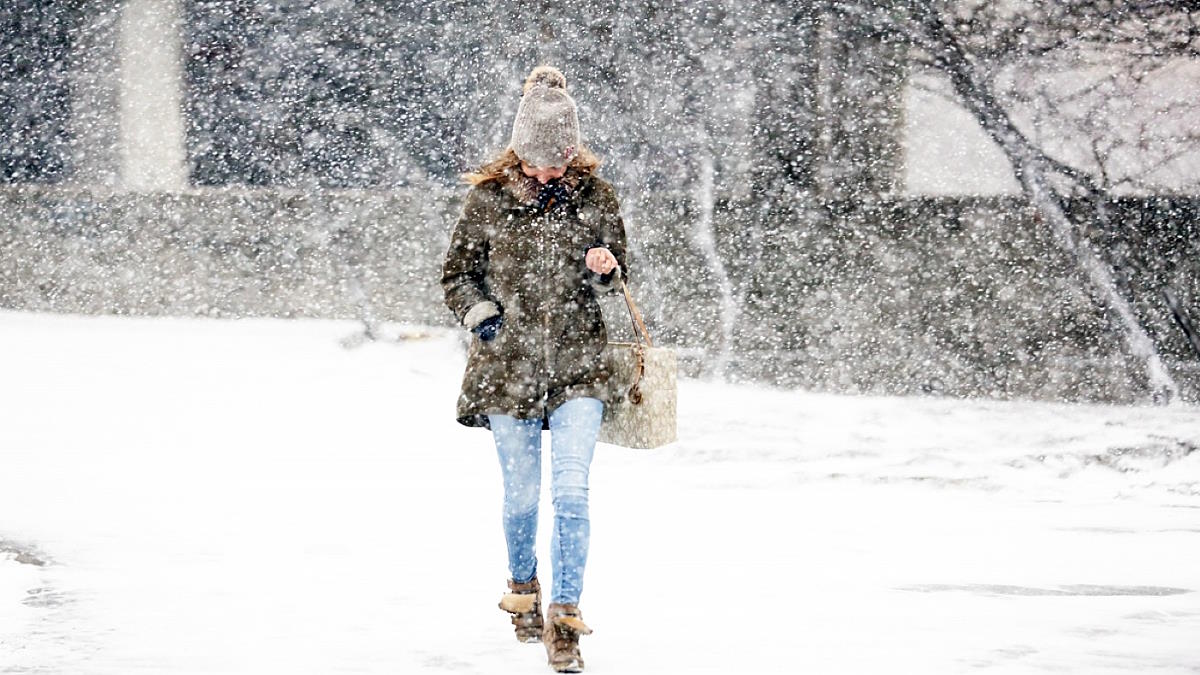 Трудно заметить залегшего в снегу. Женщины в снегопад на улице. Девушка метель. Фотосессия в Москве зимой. Девушки в пуховиках зимой.