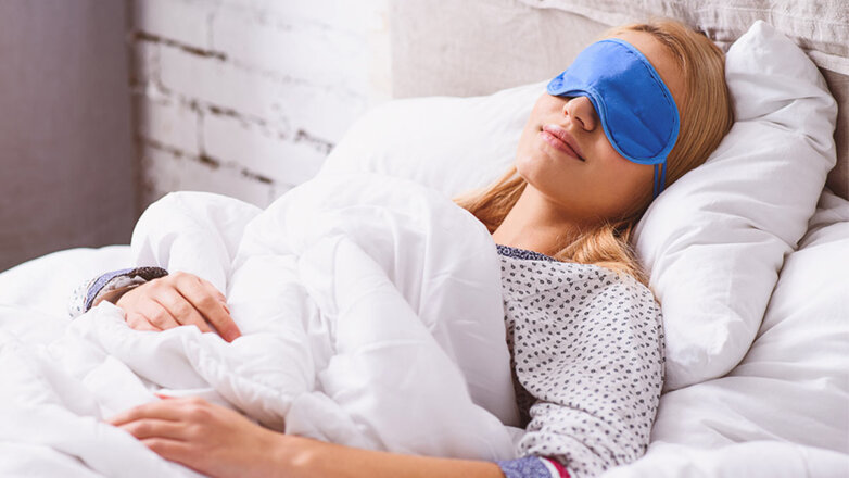 Женщина спит в маске для сна