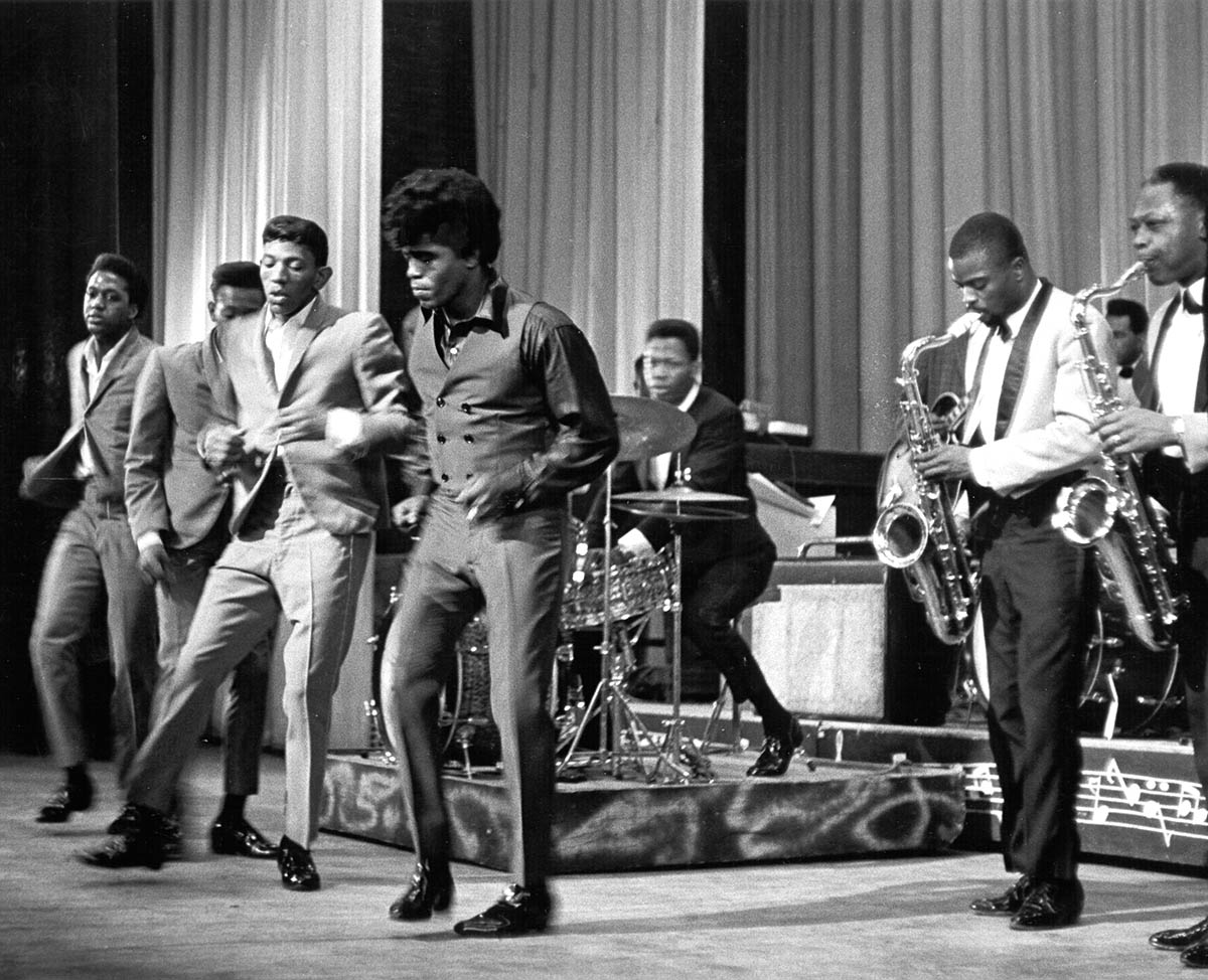 Джеймс Браун выступает на сцене с ансамблем the Famous Flames, 1964 год