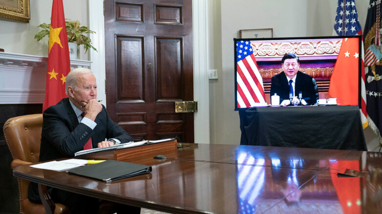 Президент США Джо Байден (за столом) и председатель КНР Си Цзиньпин (на экране)
