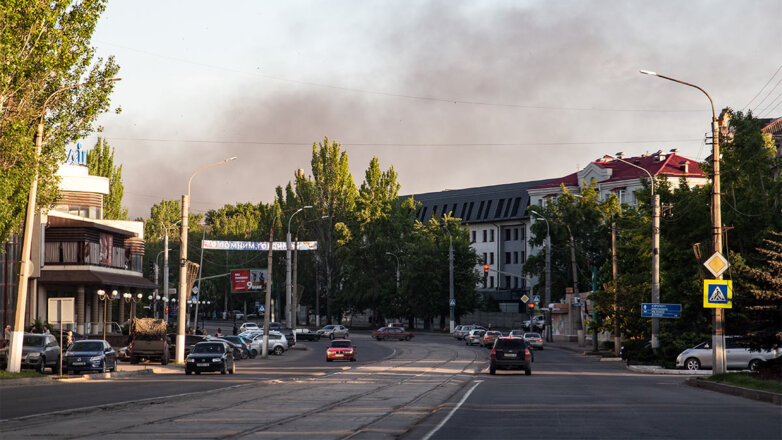 Столб дыма после падения ракет, выпущенных по Луганску