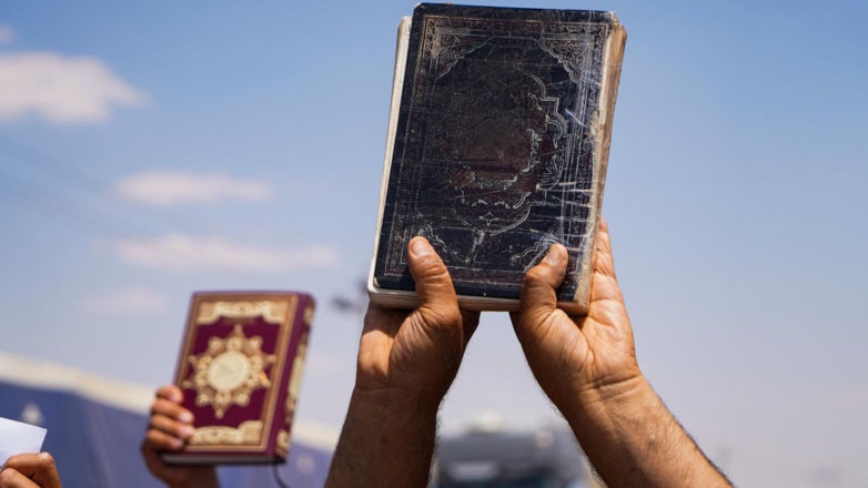 Коран в руках протестующего