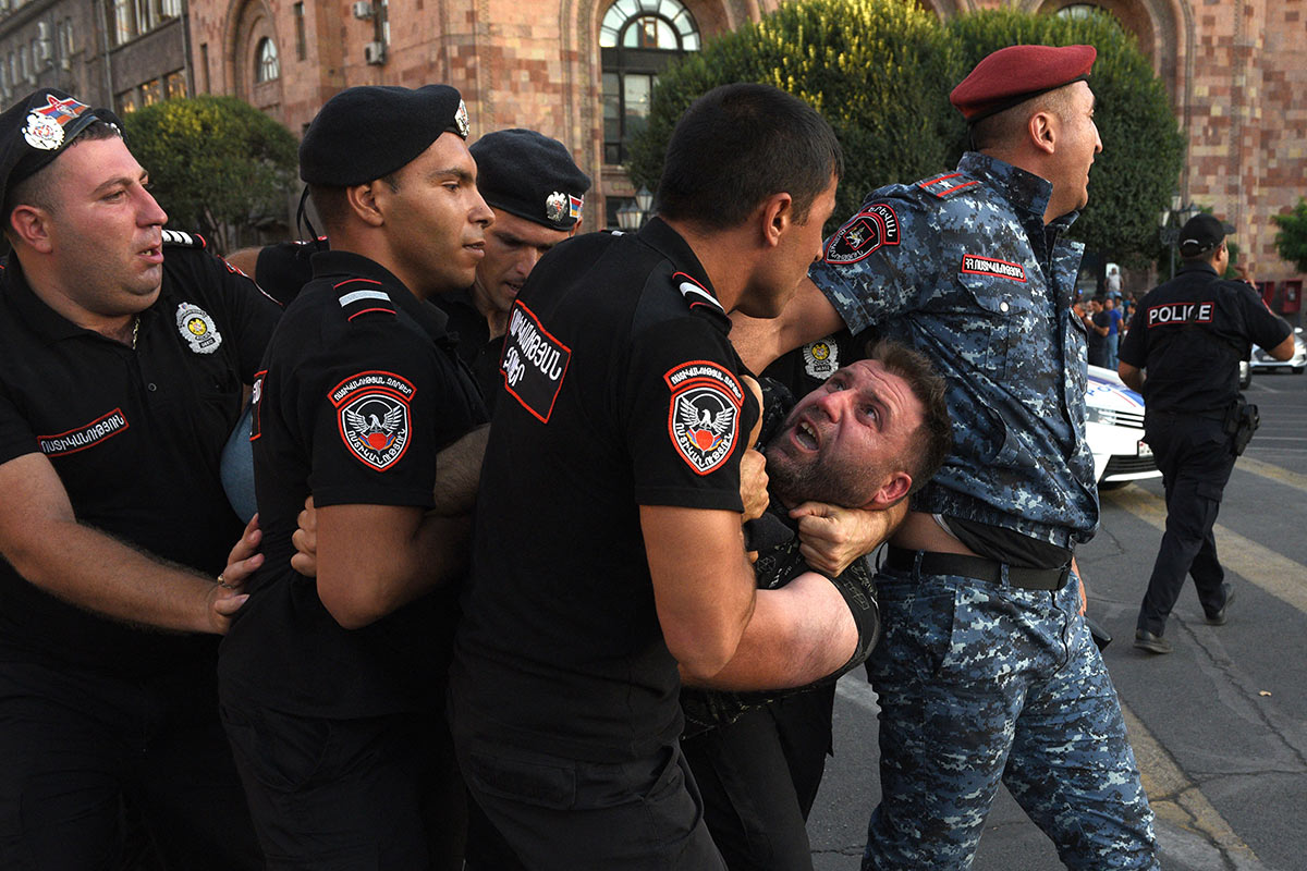 Армянские полицейские задерживают протестующего возле здания правительства в центре Еревана