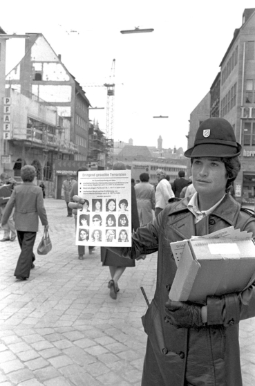 Листовки со снимками террориста распространяет женщина-полицейский в Штутгарте, Германия, 20 октября 1977 года после убийства Ханнса-Мартина Шлейера