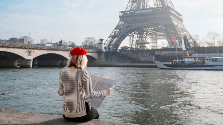 Женщина читает газету в Париже