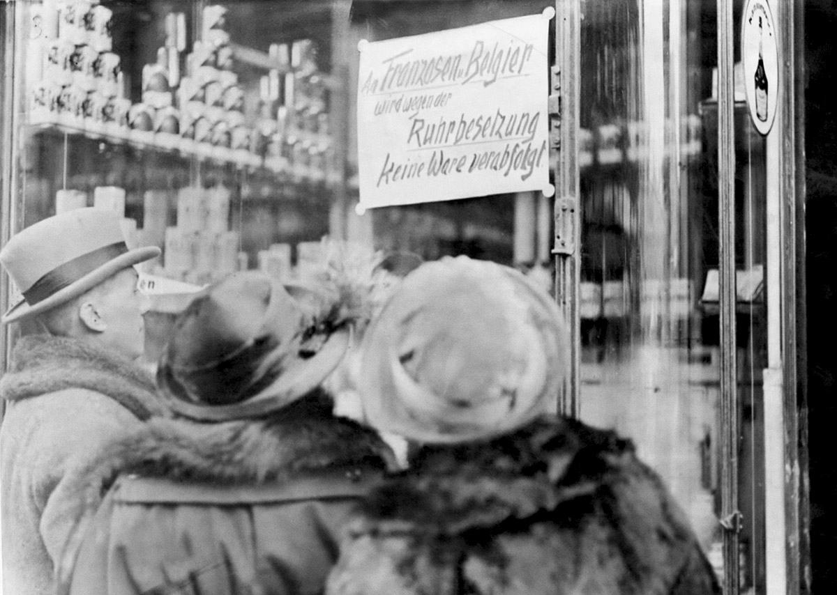 Горожане читают вывеску на магазине: "Французы и бельгийцы не будут обслуживаться из-за оккупации Рурской области ".