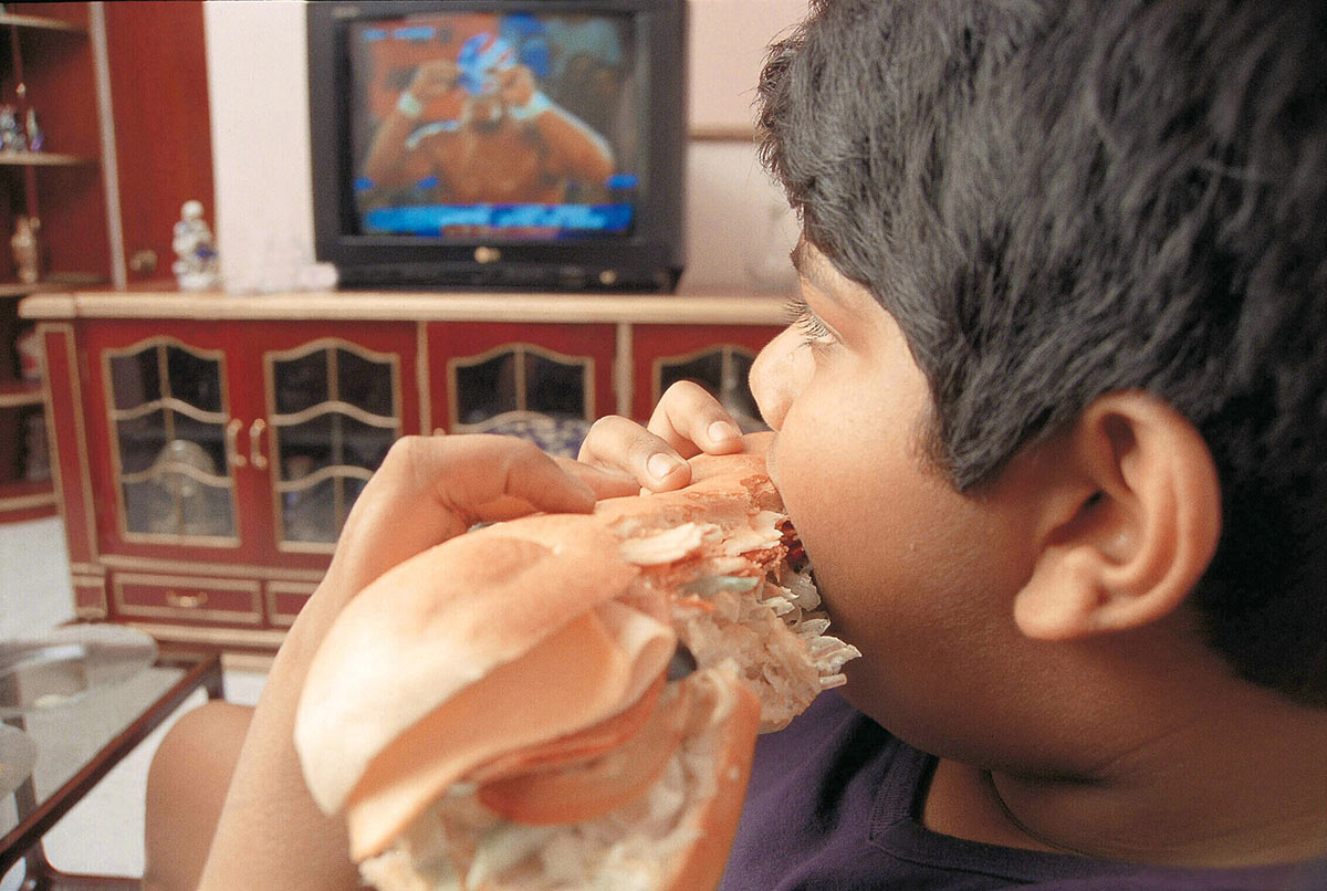 Мальчик ест бургер в Индии