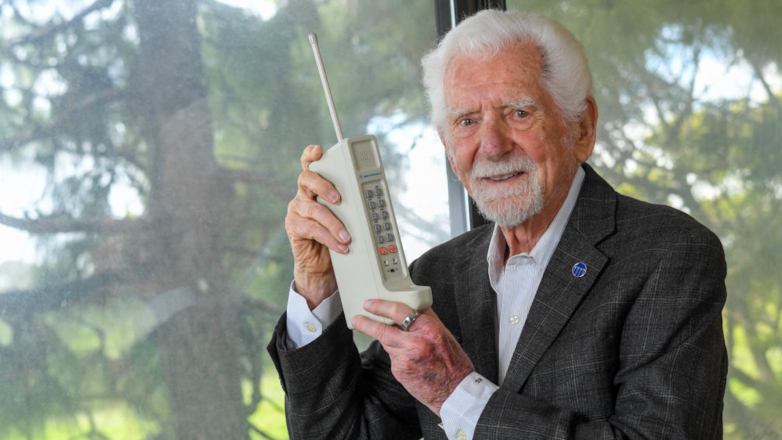 Американский инженер и физик Мартин Купер с первым мобильным телефоном