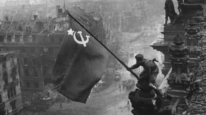 Бойцы 8-й гвардейской армии РККА Алексей Ковалев и Абдулхаким Исмаилов (слева направо) с красным знаменем на крыше здания Рейхстага после взятия Берлина советскими войсками в ходе Второй мировой войны