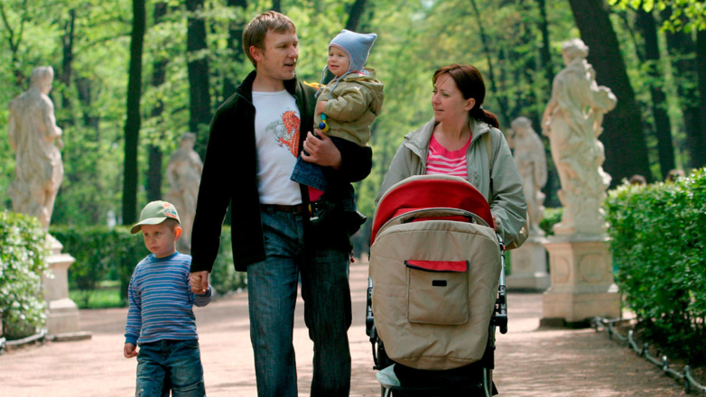 Родители с детьми гуляют в парке