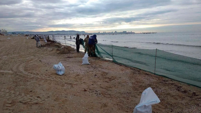 Волонтёры во время сбора разлитого мазута на пляже