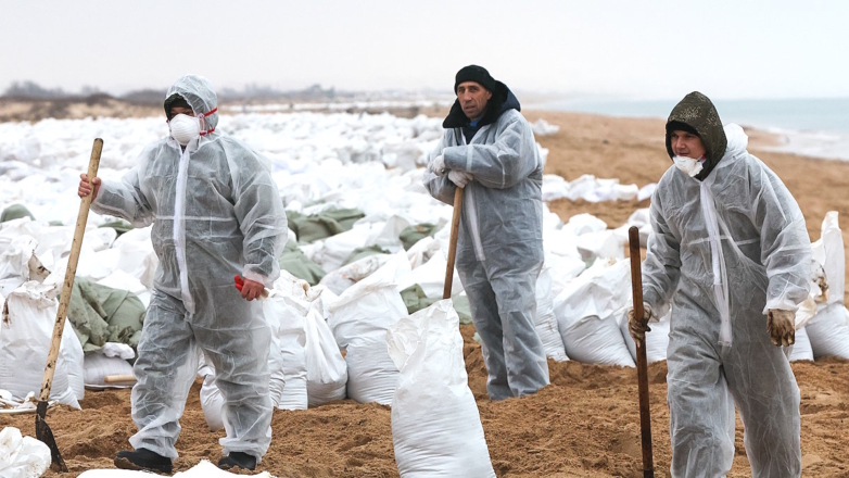 Волонтёры во время уборки разлитого мазута на пляже