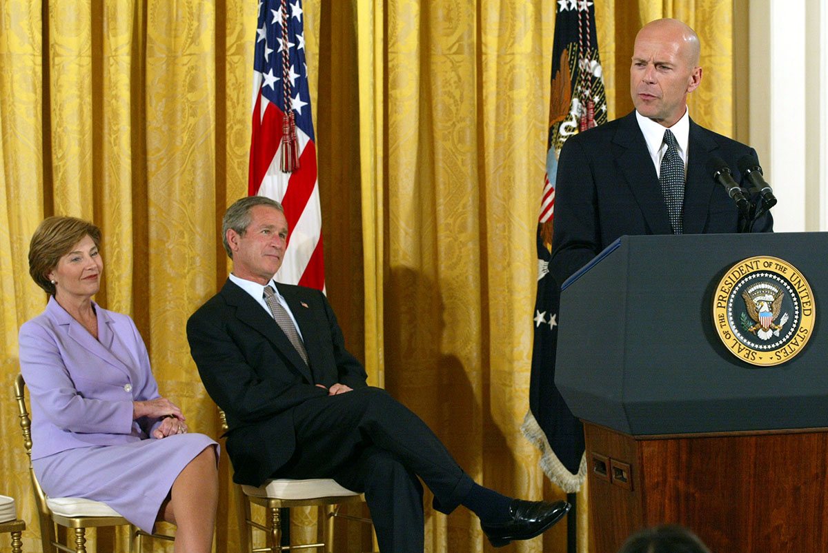 Actor Bruce Willis speaks as U.S. President George W. Bush and first lady